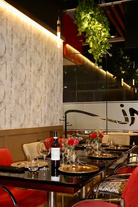 Mesa vestida con copas y rosas en el salón de Mon Ami
